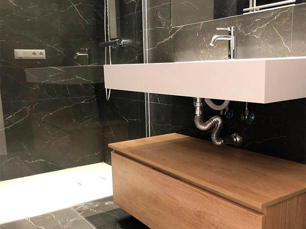 Reforma de baño con lavabo en Solid Surface y azulejos imitación mármol - Contemporánea