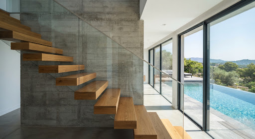Escalera volada de madera sobre hormigón visto en una obra nueva